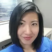 Professional woman smiling at her desk in an office setting, representing work, professionalism, success, and corporate environment.