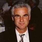 Smiling man in formal attire at professional event, showcasing leadership and confidence.