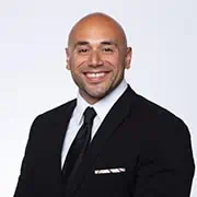 Professional businessman in a suit smiling, emphasizing corporate professionalism and business success.