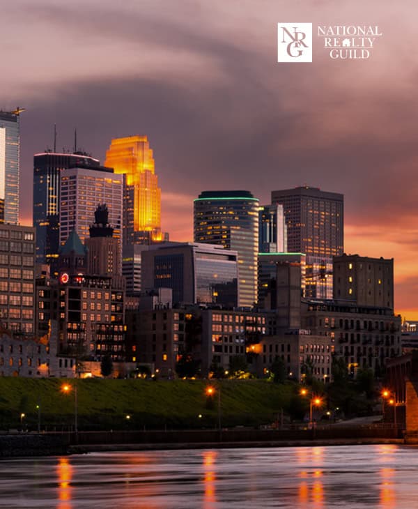 Vibrant city skyline at sunset with illuminated skyscrapers reflecting on the water, showcasing Denver's urban beauty and modern architecture, perfect for real estate or urban development visuals.